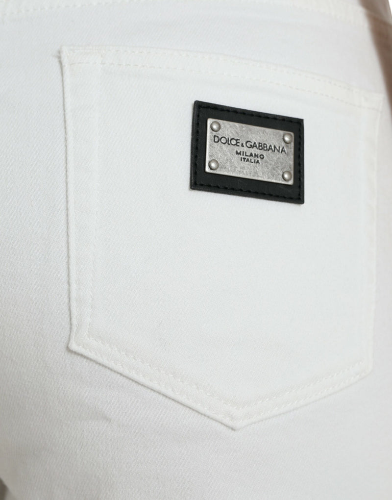 Elegantes jeans cortados de mezclilla blanca en medio de vidrio